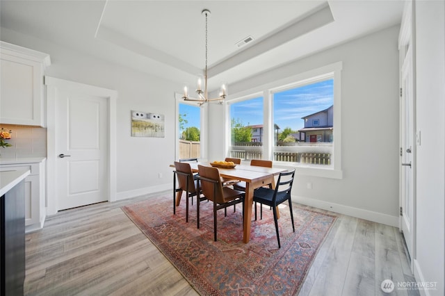 235 Champagne Way, Walla Walla, WA 99362 - dining room with a chandelier, a raised ceiling, light wood-style floors, and baseboards