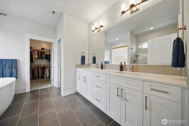 235 Champagne Way, Walla Walla, WA 99362 - bathroom with double vanity, a freestanding bath, a walk in closet, tile patterned flooring, and tiled shower