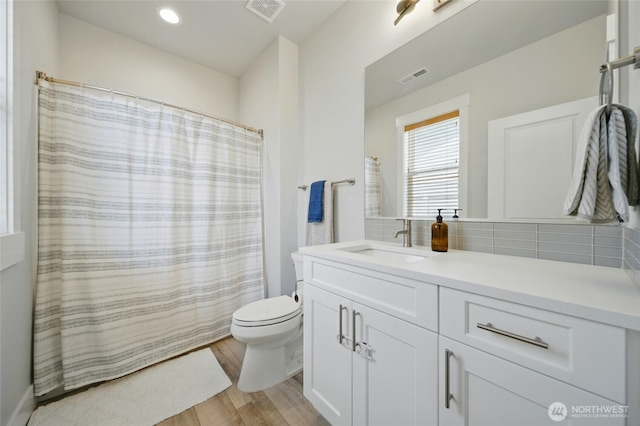 235 Champagne Way, Walla Walla, WA 99362 - bathroom with vanity, toilet, backsplash, wood finished floors, and a shower with curtain