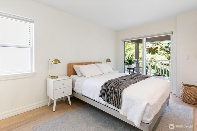 215 20th Ave E Unit 203, Seattle, WA 98112 - bedroom featuring wood finished floors, access to exterior, and baseboards