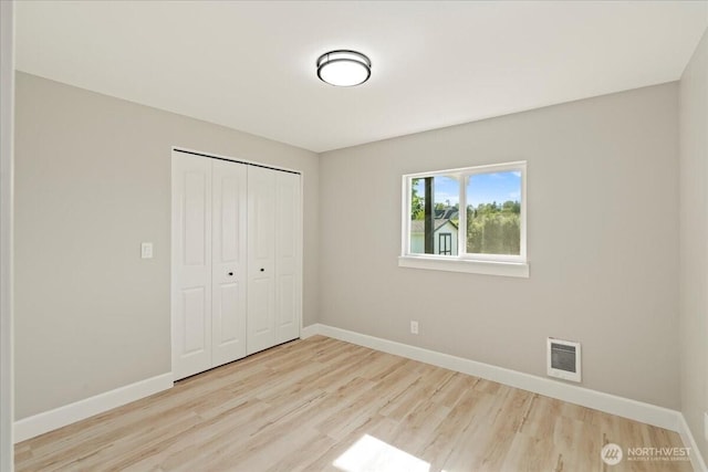 12102 19th Ct E, Edgewood, WA 98372 - unfurnished bedroom featuring wood finished floors, a closet, and baseboards