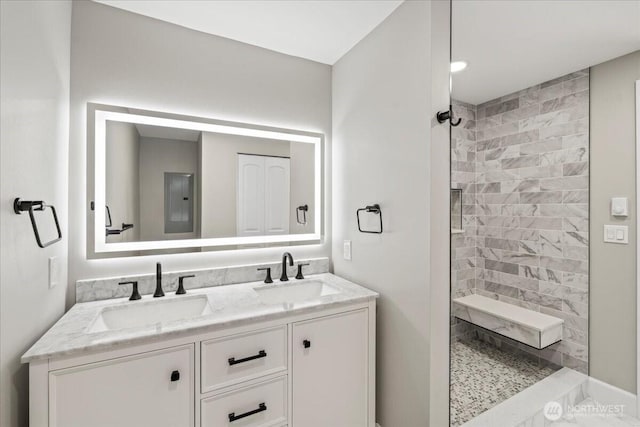 12102 19th Ct E, Edgewood, WA 98372 - full bathroom with double vanity, a tile shower, marble look tile flooring, and electric panel