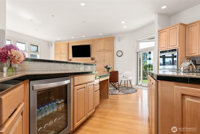 412 N 69th Ave, Yakima, WA 98908 - kitchen with beverage cooler, stainless steel oven, light brown cabinetry, plenty of natural light, and recessed lighting