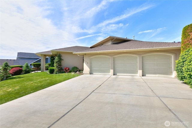 412 N 69th Ave, Yakima, WA 98908 - view of front facade with a garage, concrete driveway, stucco siding, and a front lawn