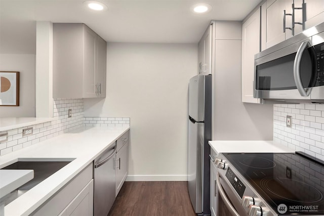 3318 30th Ave SW Unit A502, Seattle, WA 98126 - kitchen featuring appliances with stainless steel finishes, decorative backsplash, dark wood-style floors, recessed lighting, and light countertops