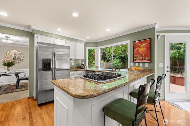 22233 NE 23rd St, Sammamish, WA 98074 - kitchen featuring stainless steel appliances, a peninsula, healthy amount of natural light, white cabinets, and crown molding