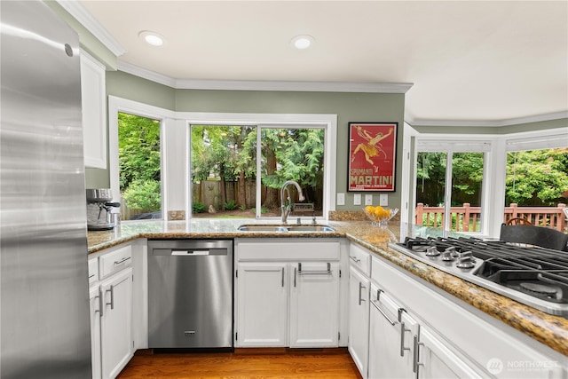 22233 NE 23rd St, Sammamish, WA 98074 - kitchen with stainless steel appliances, a sink, plenty of natural light, crown molding, and white cabinets
