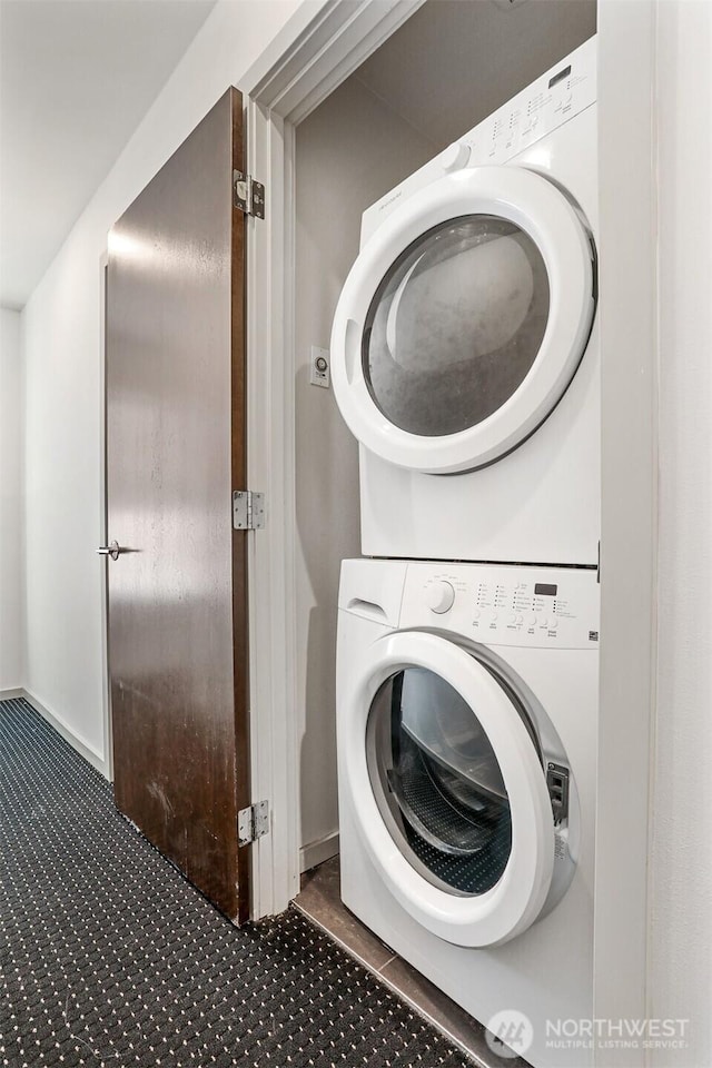 6704 15th Ave NW, Seattle, WA 98107 - laundry area with stacked washer / drying machine and tile patterned flooring