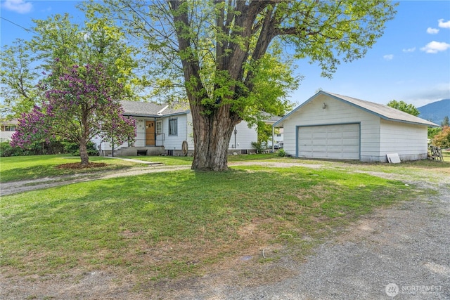 705 Old Kettle Rd, Kettle Falls, WA 99141 - view of front facade with a garage, an outbuilding, a front lawn, and dirt driveway