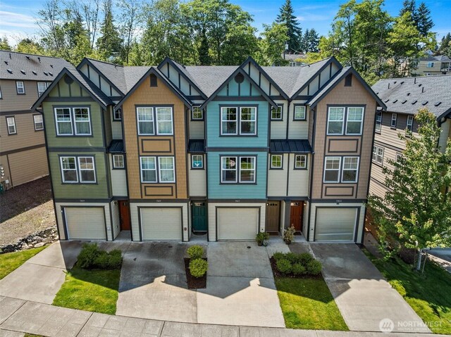 7165 27th Ave SW, Seattle, WA 98106 - view of property featuring a standing seam roof, driveway, a garage, and metal roof