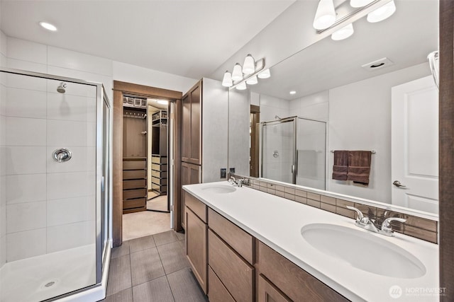 7165 27th Ave SW, Seattle, WA 98106 - full bathroom with a shower stall, a walk in closet, double vanity, recessed lighting, and tile patterned floors