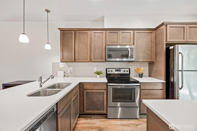 7165 27th Ave SW, Seattle, WA 98106 - kitchen with stainless steel appliances, a sink, backsplash, and light countertops