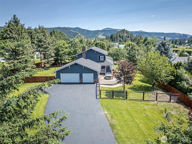 10303 Ski Hill Dr, Leavenworth, WA 98826 - view of front of house with a chimney, a gate, a garage, a mountain view, and driveway