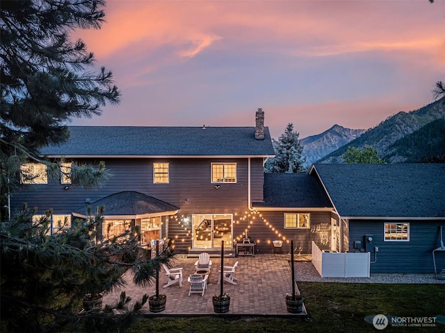 10303 Ski Hill Dr, Leavenworth, WA 98826 - back of house featuring a chimney, a patio, and a mountain view