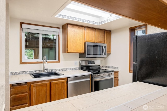 7581 Old Redmond Rd # 4, Redmond, WA 98052 - kitchen featuring appliances with stainless steel finishes, a sink, light countertops, and brown cabinets