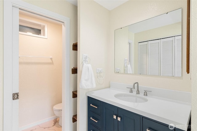 7581 Old Redmond Rd # 4, Redmond, WA 98052 - bathroom with vanity, toilet, marble finish floors, and baseboards