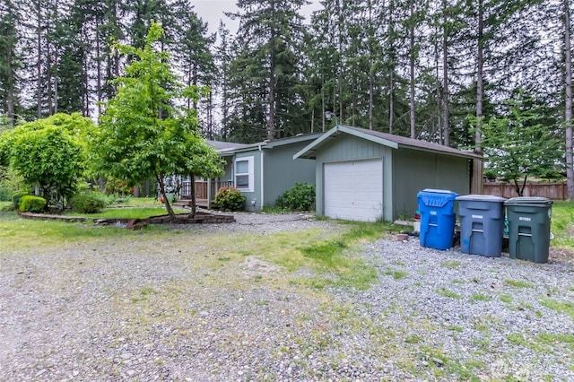 16016 11th Ave E, Tacoma, WA 98445 - view of front of home featuring a garage and view of wooded area