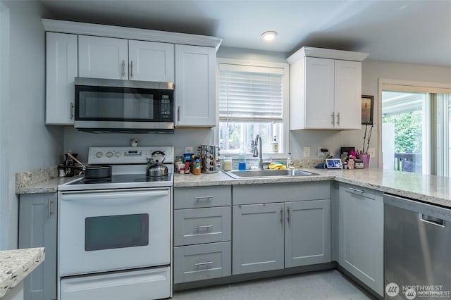 16016 11th Ave E, Tacoma, WA 98445 - kitchen featuring stainless steel appliances, a sink, white cabinetry, recessed lighting, and light stone countertops