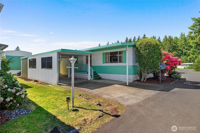 1700 E Shelton Springs Rd Unit 25, Shelton, WA 98584 - manufactured / mobile home with asphalt driveway, an attached carport, and a front lawn