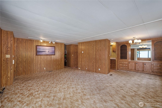1700 E Shelton Springs Rd Unit 25, Shelton, WA 98584 - unfurnished living room with carpet flooring, wooden walls, a chandelier, and rail lighting