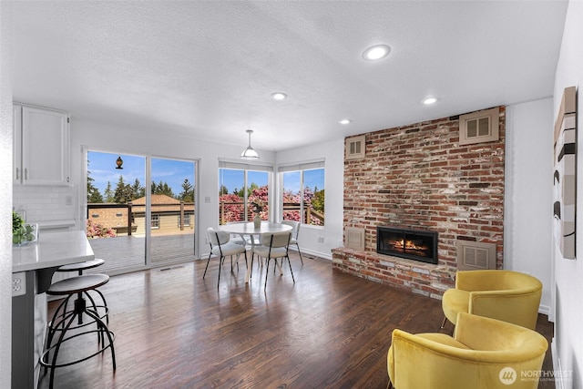 5030 155th Pl SE, Bellevue, WA 98006 - dining space with dark wood-style floors, a fireplace, a textured ceiling, and recessed lighting