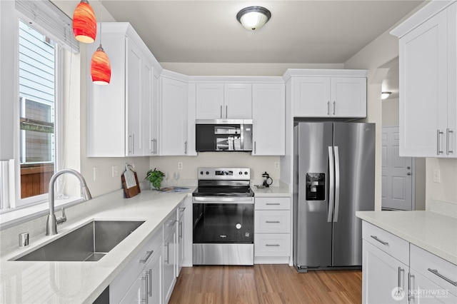 12611 13th Ave SE, Everett, WA 98208 - kitchen with appliances with stainless steel finishes, a sink, white cabinets, and light wood finished floors
