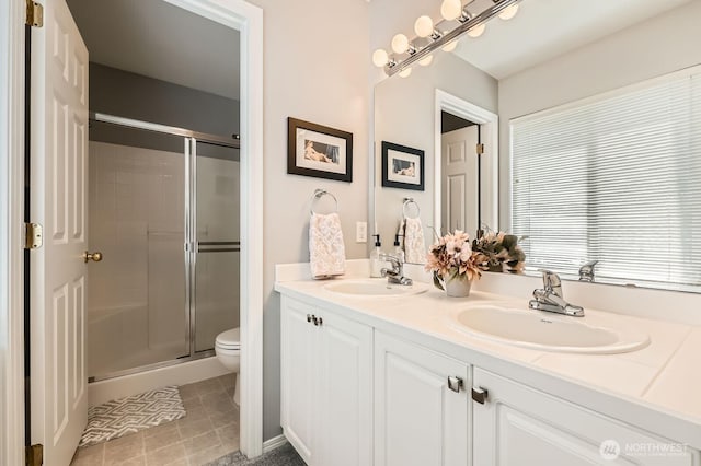 800 96th Ave NE Unit G201, Lake Stevens, WA 98258 - full bathroom featuring a stall shower, toilet, double vanity, and tile patterned flooring