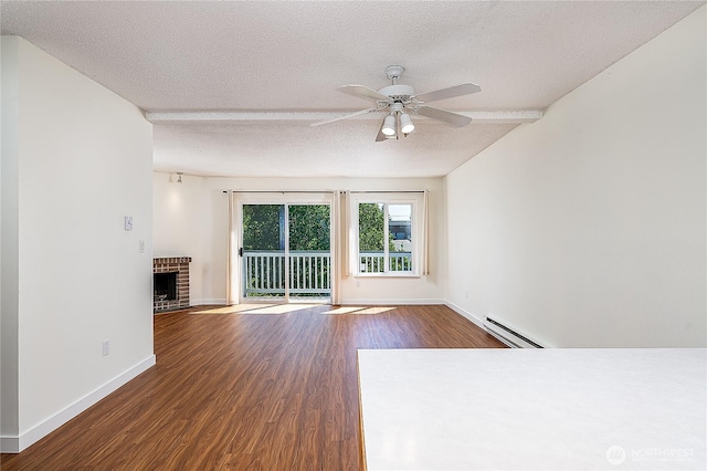 8823 Holly Dr Unit H207, Everett, WA 98208 - unfurnished living room featuring baseboard heating, wood finished floors, a textured ceiling, a ceiling fan, and baseboards