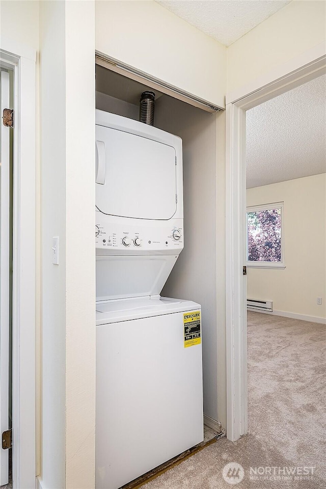 8823 Holly Dr Unit H207, Everett, WA 98208 - washroom with stacked washer / dryer, baseboard heating, carpet floors, a textured ceiling, and baseboards