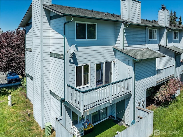 8823 Holly Dr Unit H207, Everett, WA 98208 - back of house featuring a chimney, a lawn, a wooden deck, and roof with shingles