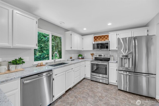 10704 25th Pl NE, Lake Stevens, WA 98258 - kitchen featuring stainless steel appliances, a sink, white cabinetry, light stone countertops, and recessed lighting