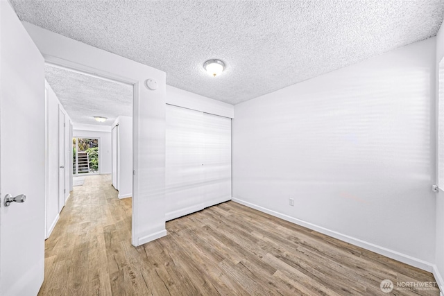 1338 Orleans St, Bellingham, WA 98229 - unfurnished bedroom with light wood-style flooring, a textured ceiling, baseboards, and a closet