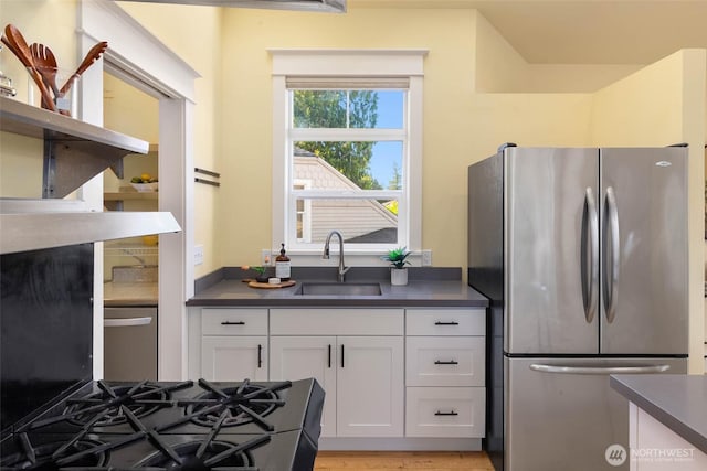 11744 NE Sand Point Way, Seattle, WA 98125 - kitchen featuring freestanding refrigerator, a sink, dark countertops, and white cabinetry