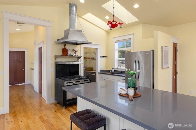11744 NE Sand Point Way, Seattle, WA 98125 - kitchen with freestanding refrigerator, dark countertops, a sink, island exhaust hood, and a skylight