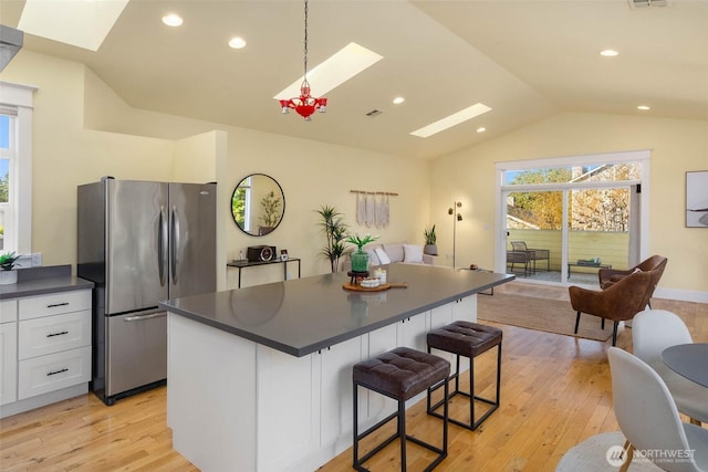 11744 NE Sand Point Way, Seattle, WA 98125 - kitchen with freestanding refrigerator, a skylight, dark countertops, lofted ceiling, and white cabinetry
