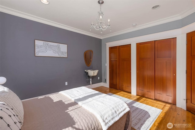 11744 NE Sand Point Way, Seattle, WA 98125 - bedroom featuring a chandelier, multiple closets, light wood-style floors, ornamental molding, and recessed lighting