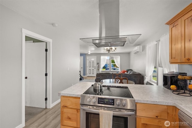 505 Herren Ave, Winlock, WA 98596 - kitchen with appliances with stainless steel finishes, island exhaust hood, a wall mounted AC, open floor plan, and light wood finished floors