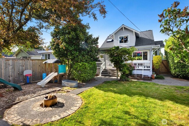 3201 SW Genesee St, Seattle, WA 98126 - rear view of property with a playground, a fire pit, and a shingled roof