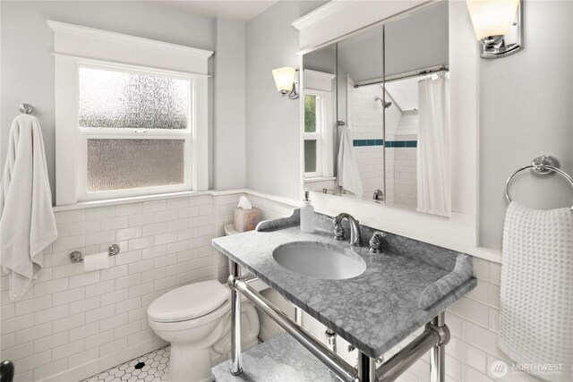 3201 SW Genesee St, Seattle, WA 98126 - bathroom with tile walls, tile patterned floors, wainscoting, toilet, and a shower with curtain