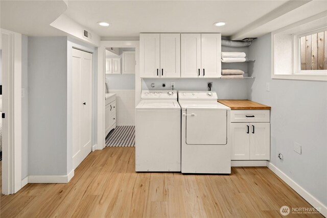 3201 SW Genesee St, Seattle, WA 98126 - washroom featuring cabinet space, separate washer and dryer, light wood finished floors, baseboards, and recessed lighting