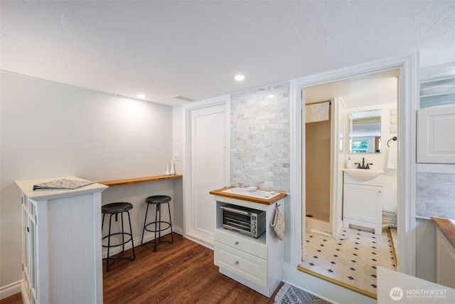 410 N 48th St, Seattle, WA 98103 - kitchen with a kitchen bar, a sink, and dark wood finished floors