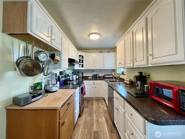 30 Hemlock St N, Soap Lake, WA 98851 - kitchen with appliances with stainless steel finishes, a sink, under cabinet range hood, light wood-style floors, and white cabinets