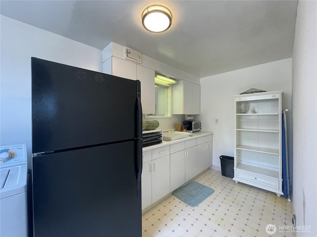 30 Hemlock St N, Soap Lake, WA 98851 - kitchen featuring freestanding refrigerator, washer / clothes dryer, light countertops, white cabinetry, and a sink