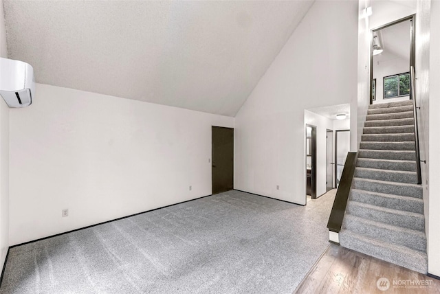 33 N Summit Dr, Bellingham, WA 98229 - unfurnished living room with lofted ceiling, a wall unit AC, stairs, and wood finished floors