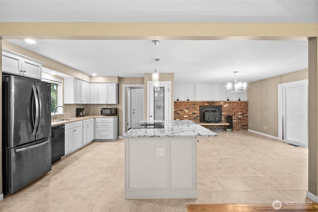25721 173rd Ave SE, Covington, WA 98042 - kitchen with black appliances, a sink, a kitchen island, white cabinets, and backsplash
