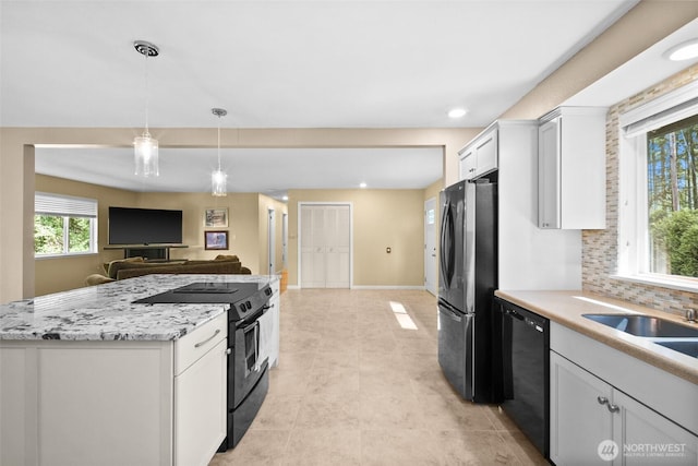 25721 173rd Ave SE, Covington, WA 98042 - kitchen featuring black appliances, open floor plan, white cabinets, healthy amount of natural light, and recessed lighting