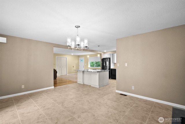 25721 173rd Ave SE, Covington, WA 98042 - kitchen with a chandelier, baseboards, a center island, and freestanding refrigerator