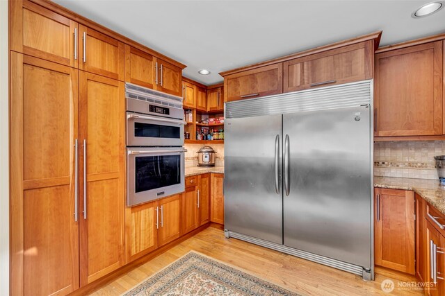 6490 NE Monte Vista Dr, Bainbridge Island, WA 98110 - kitchen featuring appliances with stainless steel finishes, recessed lighting, brown cabinetry, and light wood-style flooring