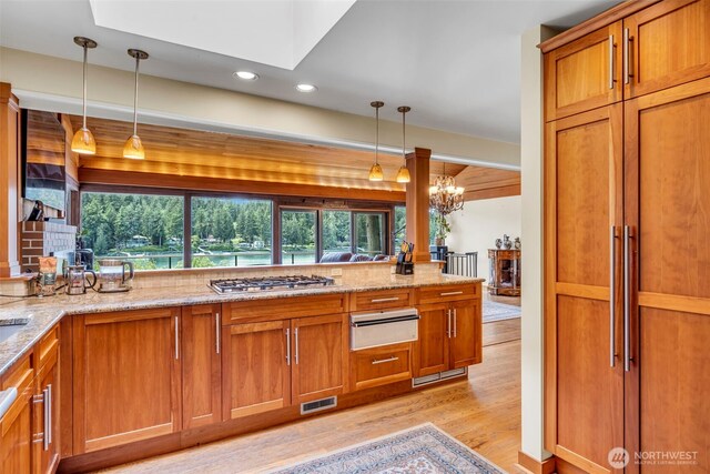 6490 NE Monte Vista Dr, Bainbridge Island, WA 98110 - kitchen with a warming drawer, light wood-style flooring, stainless steel gas stovetop, brown cabinetry, and recessed lighting