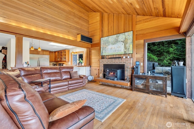 6490 NE Monte Vista Dr, Bainbridge Island, WA 98110 - living room with wooden walls, wood ceiling, light wood-style flooring, high vaulted ceiling, and a wood stove